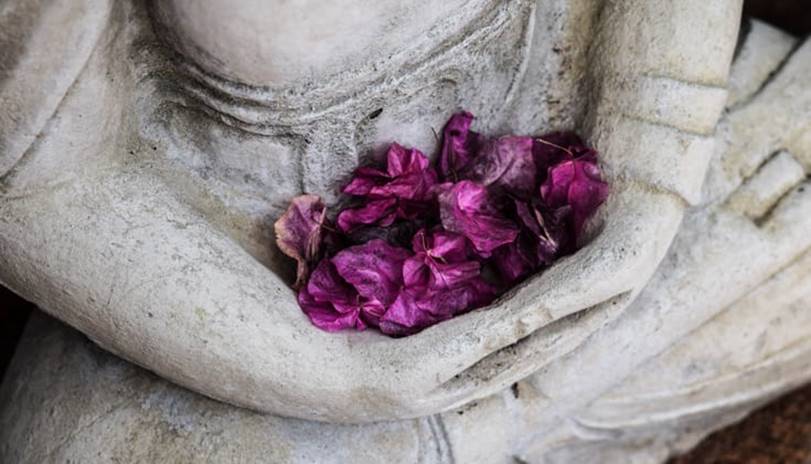 Buddha statue holding flowers.